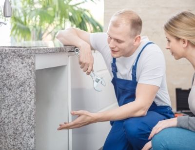 plumber gesturing under sink